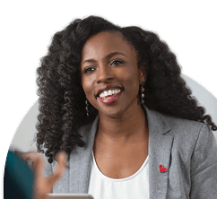 A woman sitting in front of a laptop and smiling